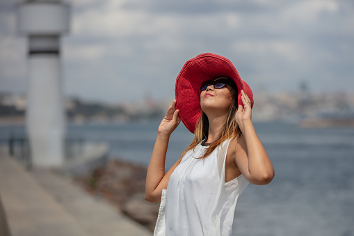 Portrait of young asian lady with pink hat in front of Istanbul cityscape.