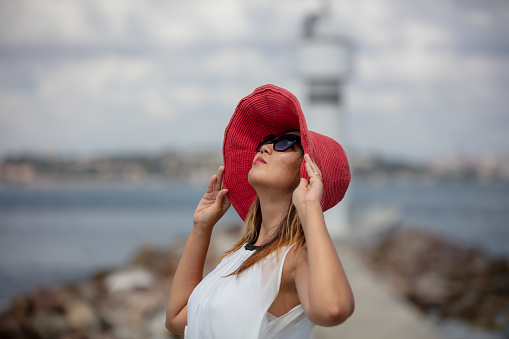 Portrait of young asian lady with pink hat in front of Istanbul cityscape.