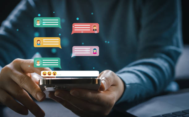 istock Human hand using smartphone typing Live chat chatting and social network concepts, chatting conversation working at home in chat box icons pop up. Social media marketing technology concept 1673754378