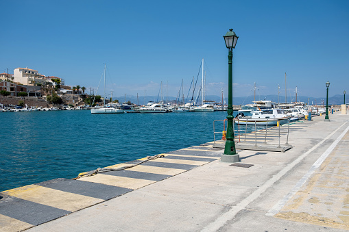 Megalochori, Milos, Miloi port Agistri island Greece. Seaside building, harbor with bollard and moored yacht, calm sea, blue sky. Sunny day