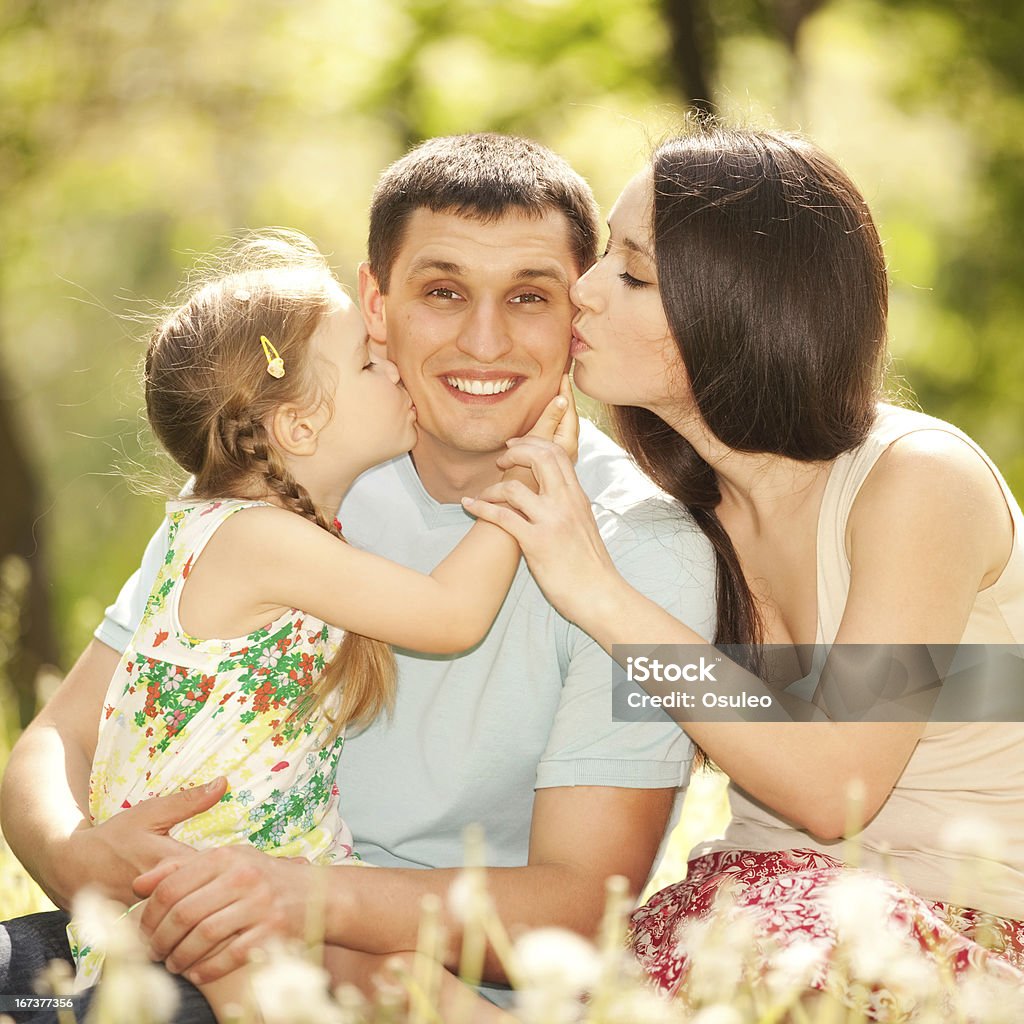 Felice Madre, Padre e figlia nel parco - Foto stock royalty-free di Abbracciare una persona