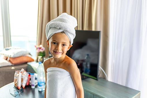 Relaxed young Caucasian boy wears towel wrapped on head
