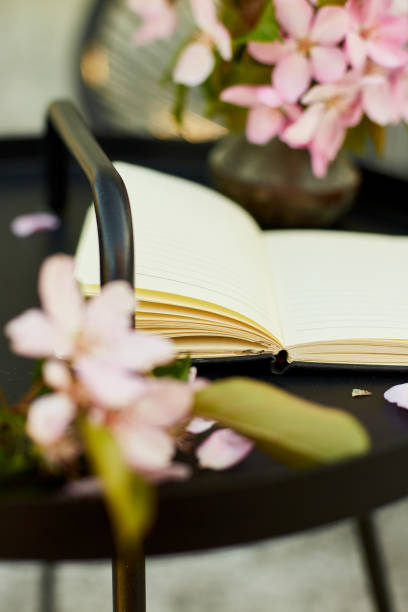 istock Open notebook and flowers and on the small black table on terrace 1673781608