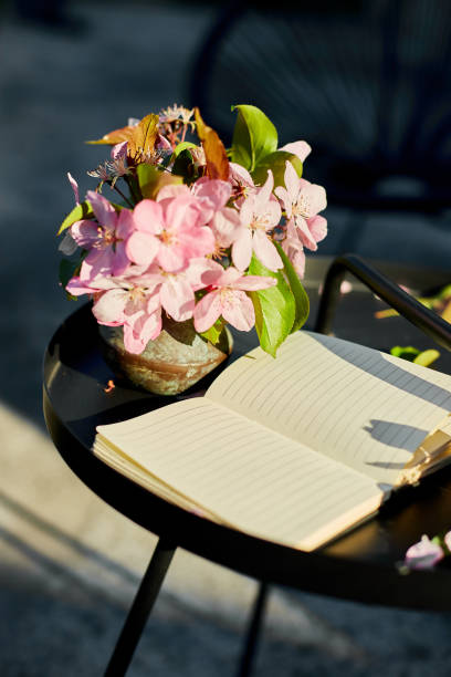 istock Open notebook and flowers and on the small black table on terrace 1673781613