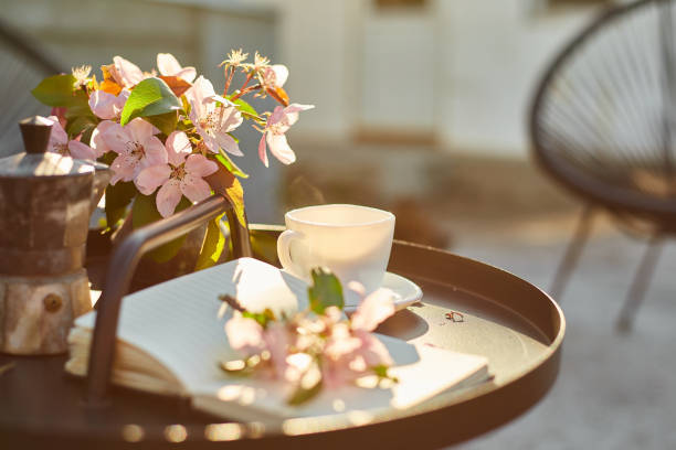 istock Cup of coffee flowers and notebook on the small black table 1673781822