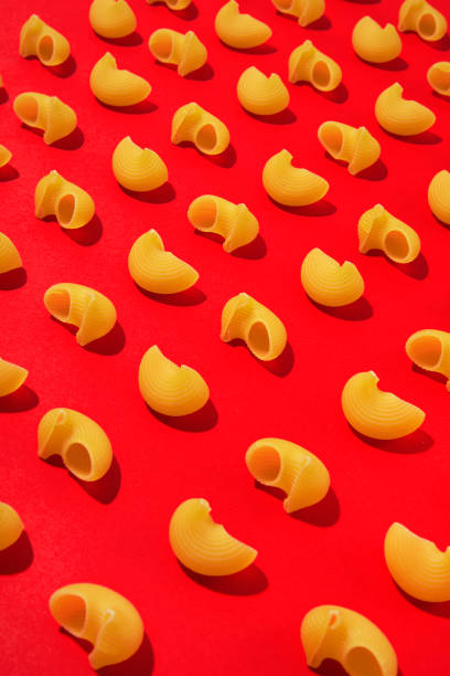 Pasta repetition flat lay on red colored background.