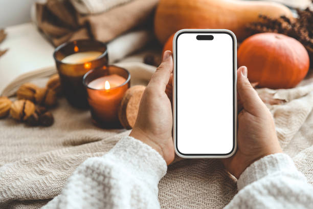 istock Phone with an isolated screen in hands, autumn mood 1673818604