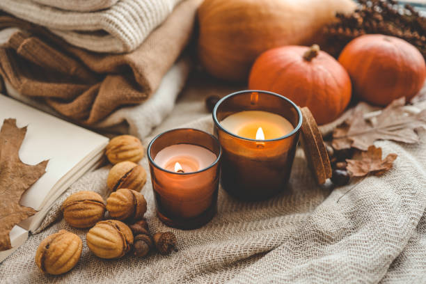 istock Two burning candles in the autumn interior 1673820226