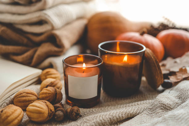 istock Burning candle with label isolated in autumn interior 1673820227