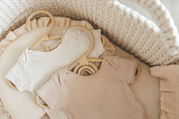 istock Two neutral bodysuits in a baby cradle, baby clothes 1673823686
