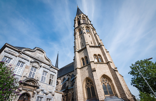 Low angle view of church in Aachen city center against blue sky.