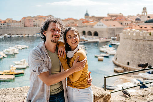 Young tourist couple embracing in Dubrovnik bay in Croatia.