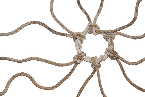 Natural colored ropes from different directions join together in a knotted ring, symbol of solidarity and cohesion, isolated on a white background, copy space