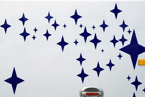 Blue stars on a white wall of a car door in the background
