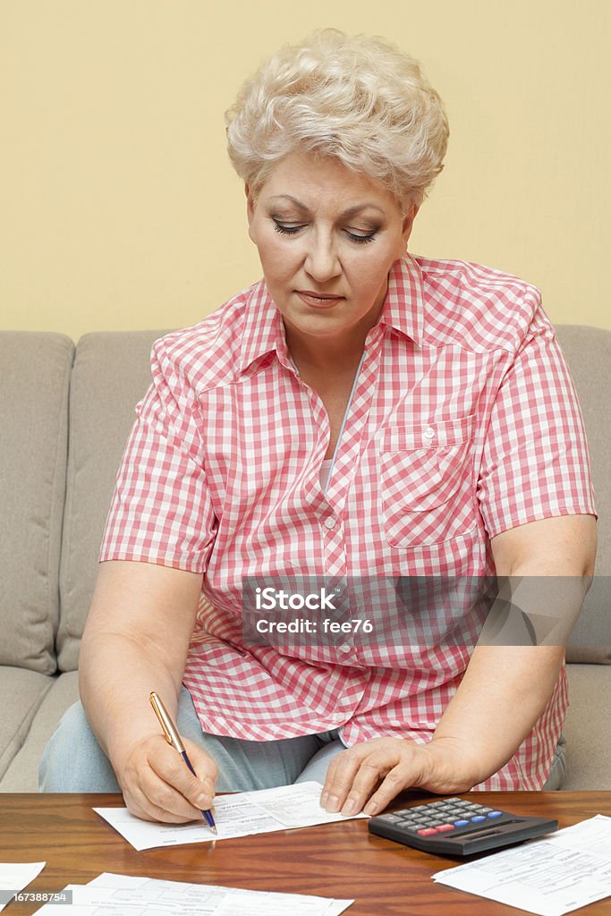 Ejecutivo de cálculo de sus deudas y escribir - Foto de stock de Adulto libre de derechos