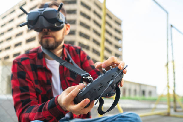 istock Male fpv pilot taking part in multicopter drones racing competition using goggles and remote controller 1673906379