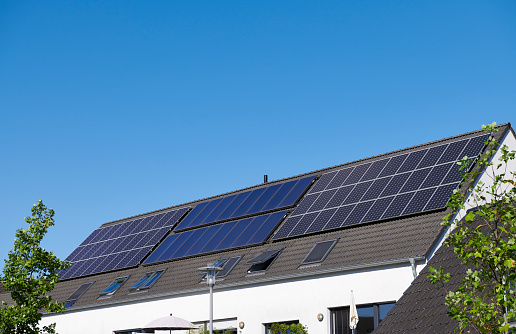 Solar panels and solar thermal collectors on the roof of a contemporary multi family house.