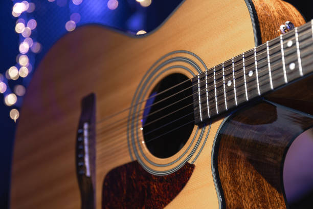 istock Close-up, acoustic guitar on a dark background with bokeh lights. 1673939523