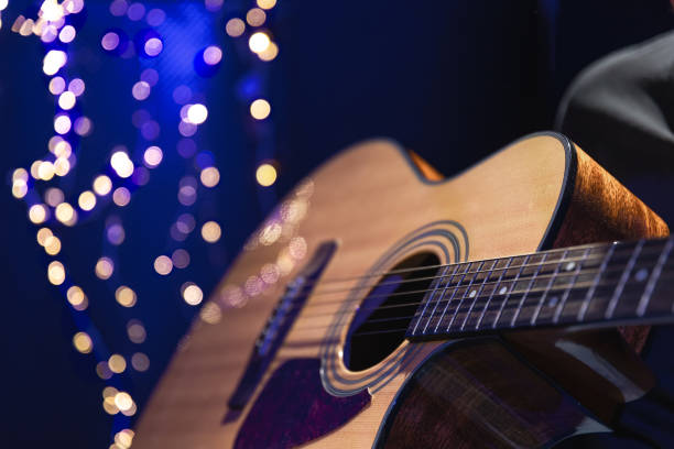 istock Close-up, acoustic guitar on a dark background with bokeh lights. 1673939525