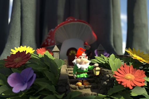 Garden gnome in front of black background relaxing on top of green grass in the middle of the night.