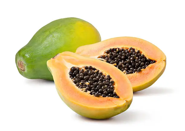Half cut and whole papaya fruits on white background