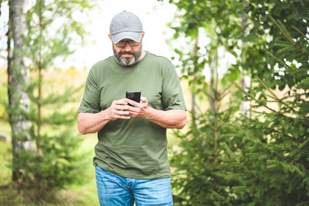 istock man walking in the park with a mobile phone 1673985358