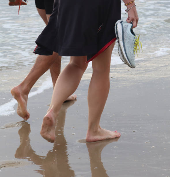 istock legs of people walking on the beach- 1673989188