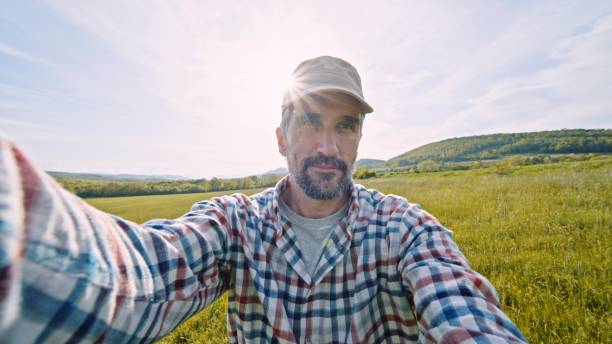 Farmer vlogging in wheat crops at sunset in spring.