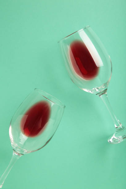 istock Glasses with red wine lying on mint background, top view. Flat lay 1673997367