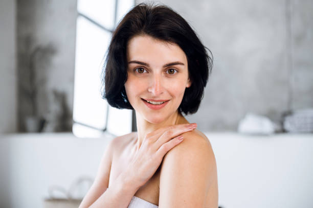 istock Woman touching shoulder, feeling soft smooth skin and smile 1673998522