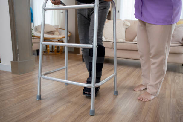istock Closeup leg senior woman helping and support elderly man while walking with walker for rehabilitation and therapy together in living room at home, senior couple and relation, medical concept. 1673999806