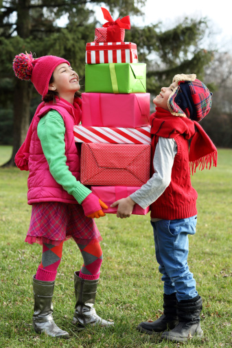 Children holding stack of gift boxes 
