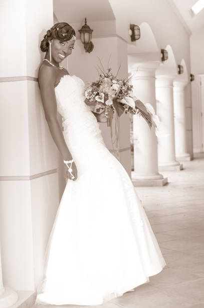 Vintage style photo of a beautiful woman in a wedding dress holding a bouquet of flowers.