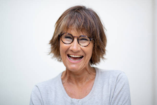 istock Close up older woman laughing with eyeglasses by white background 1674012496