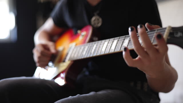 Young boy play electric guitar at home