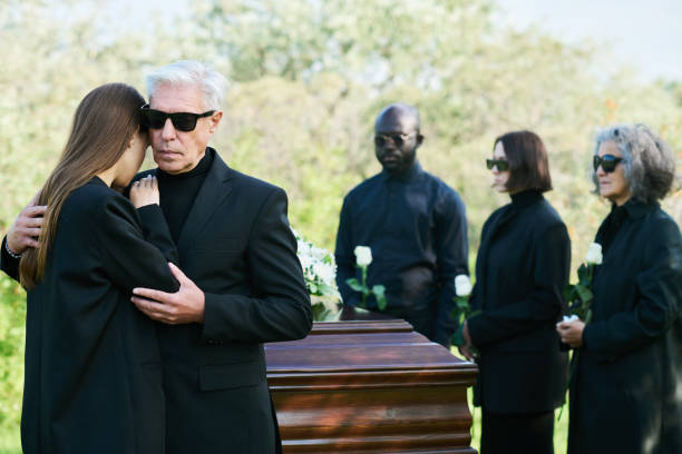 istock Grieving mature man in black suit embracing his mourning daughter 1674039875