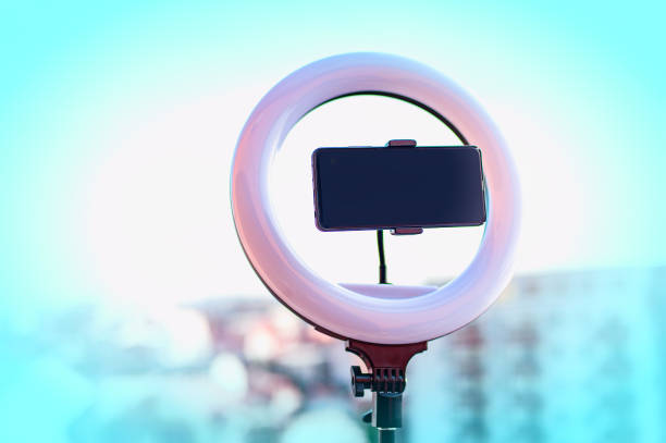 スマートフォンと自撮りledリングライト。ブイログ機器。屋外の背景。 - times square flash ストックフォトと画像