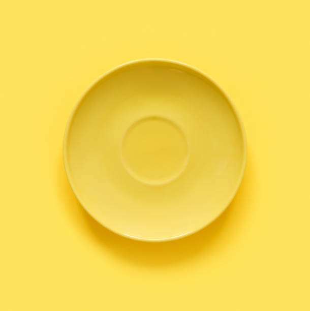 istock Yellow plates on yellow table. Monochrome minimalistic image in hipster style. 1674068337