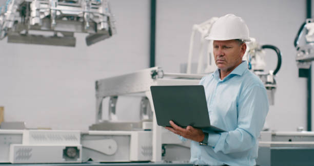istock Inspection, engineering and a man with a laptop for robotics, manufacturing or check in a workshop. Mechanic, technology and a mature technician with a computer for control of a machine in a factory 1674079361