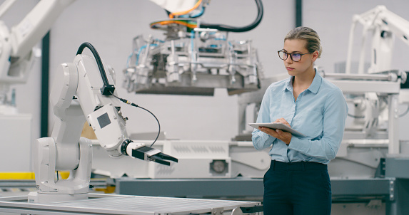 Tablet, automation and manufacturing with woman in factory for robotics, futuristic and production. Inspection, technology and ai software with person for engineering, industry 4.0 and electronics