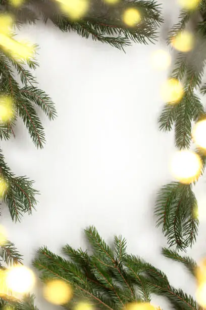 frame of fir branches decorated with garland lights, top view