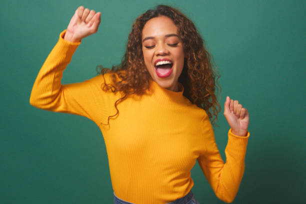 istock Happy young woman dancing, having fun, green studio background 1674101878