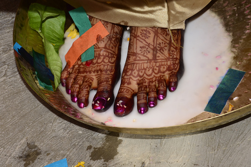 Image of a Hindu bride washing feet during the traditional wedding ceremony