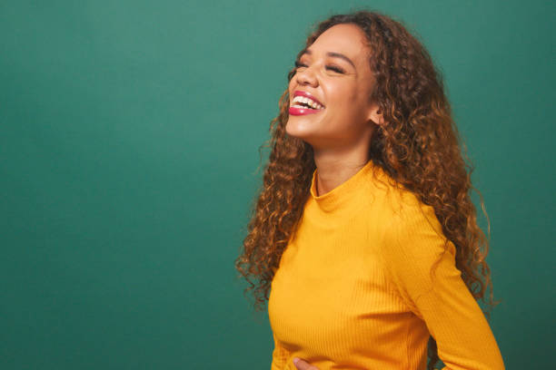 istock Beautiful multi-ethnic woman laughing portrait, green studio backdrop 1674117528