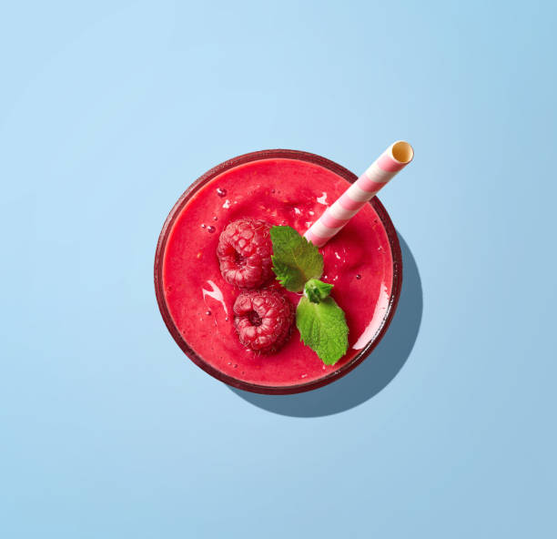 glas himbeer-smoothie auf blauem hintergrund - drinking straw juice frozen glass stock-fotos und bilder