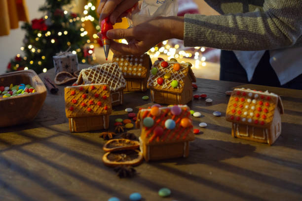 istock Woman is decorating small gingebread houses with candies 1674135969