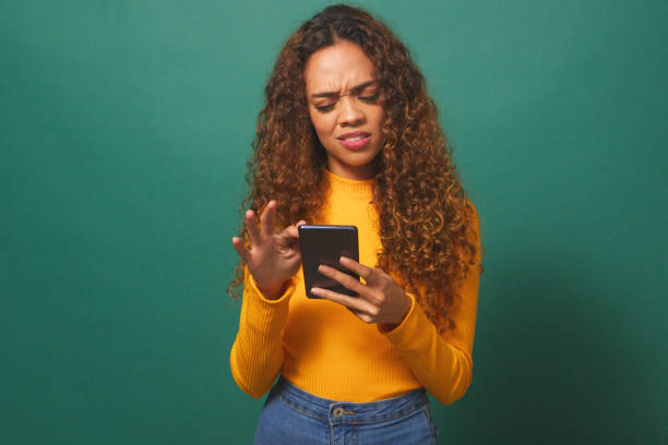 istock Young woman reads text message, disappointed confused, green studio background 1674137212