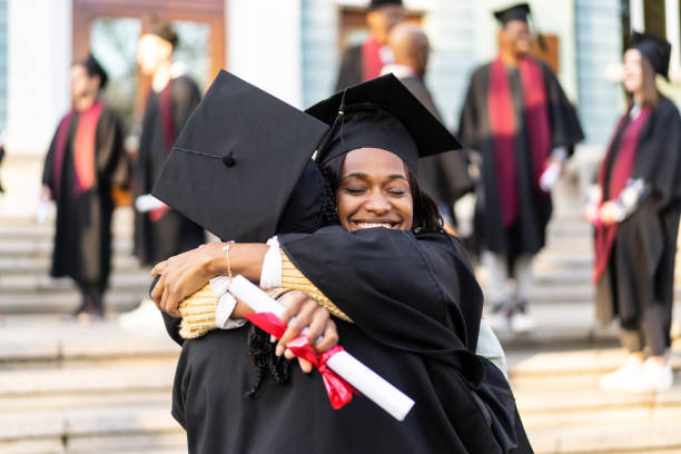 istock Two female graduates embracing each other 1674137754