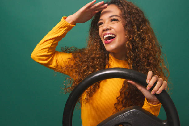 Woman driving car admires view, tourist vacation car hire, green studio backdrop stock photo