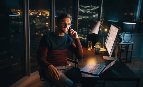 istock Late-night work calls: Businessman balances home office and work tasks 1674139503
